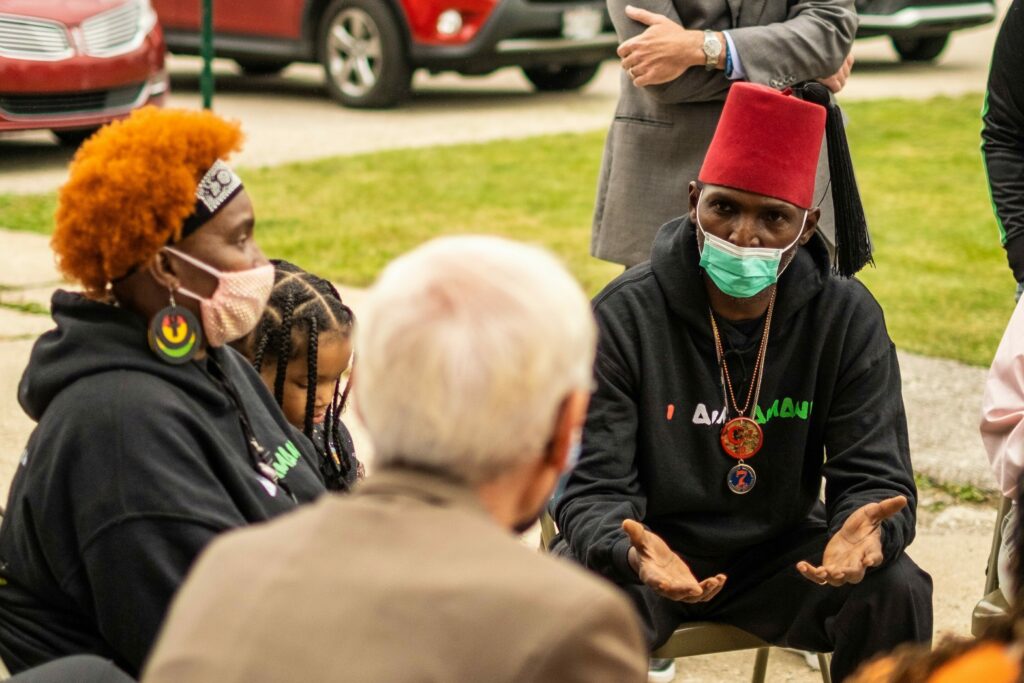 Outdoor gathering with individuals engaged in discussion in a casual park-like setting